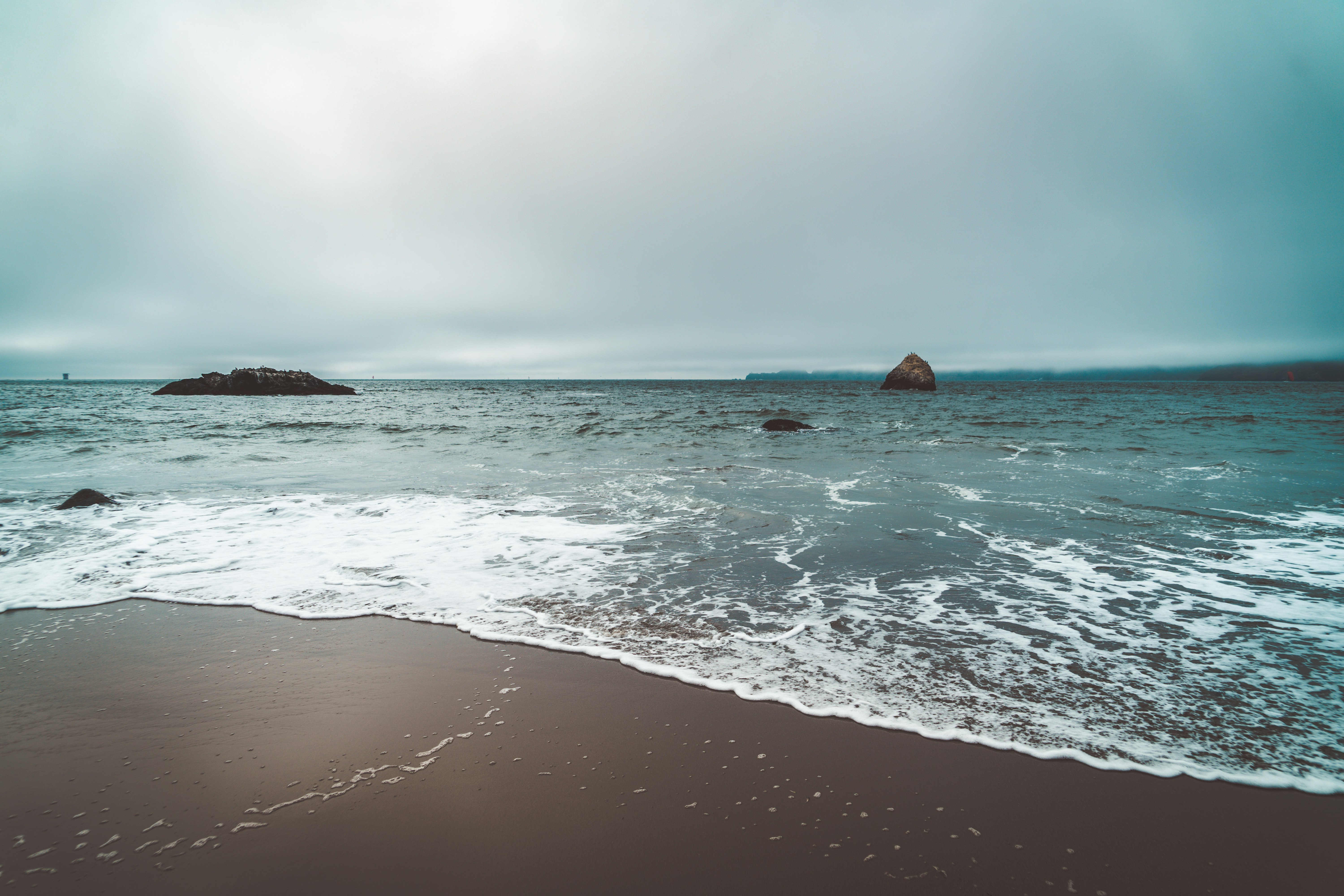 ocean waves crashing on shore during daytime